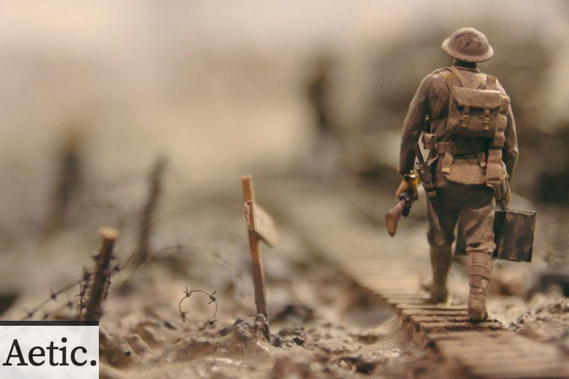soldier walking on wooden pathway surrounded with barbwire selective focus photography