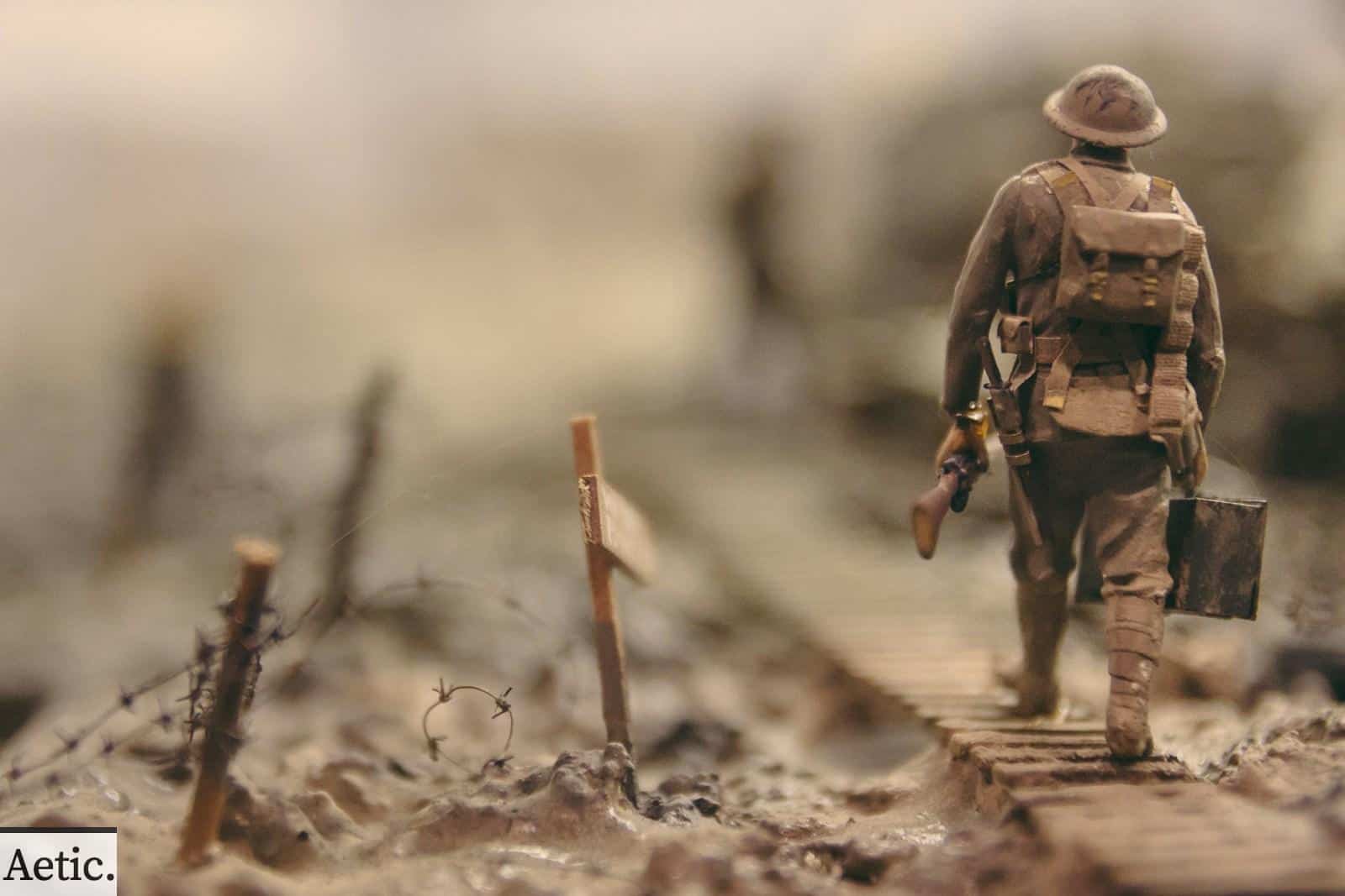 soldier walking on wooden pathway surrounded with barbwire selective focus photography