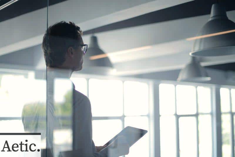 Formal man with tablet giving presentation in office