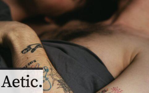 Tattooed Man Lying in Bed With Man