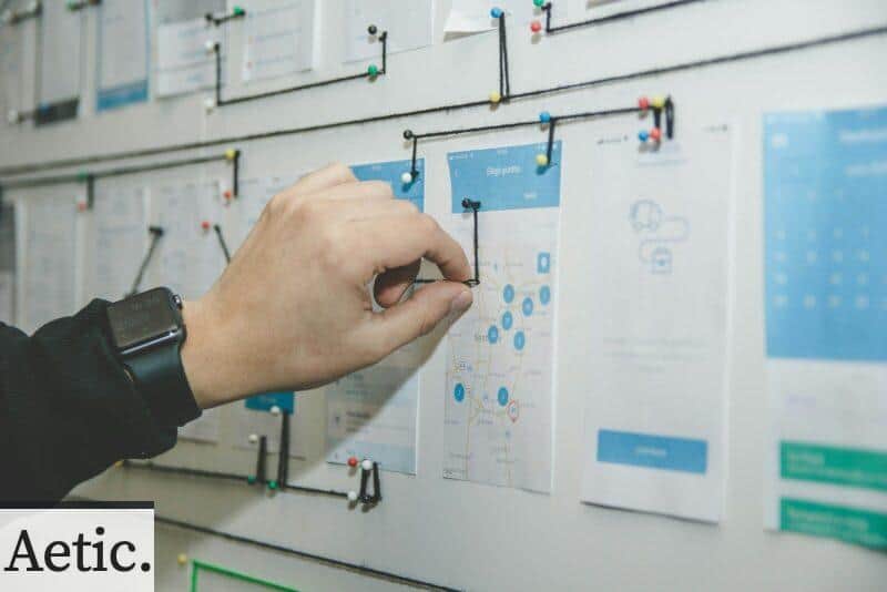 person working on blue and white paper on board