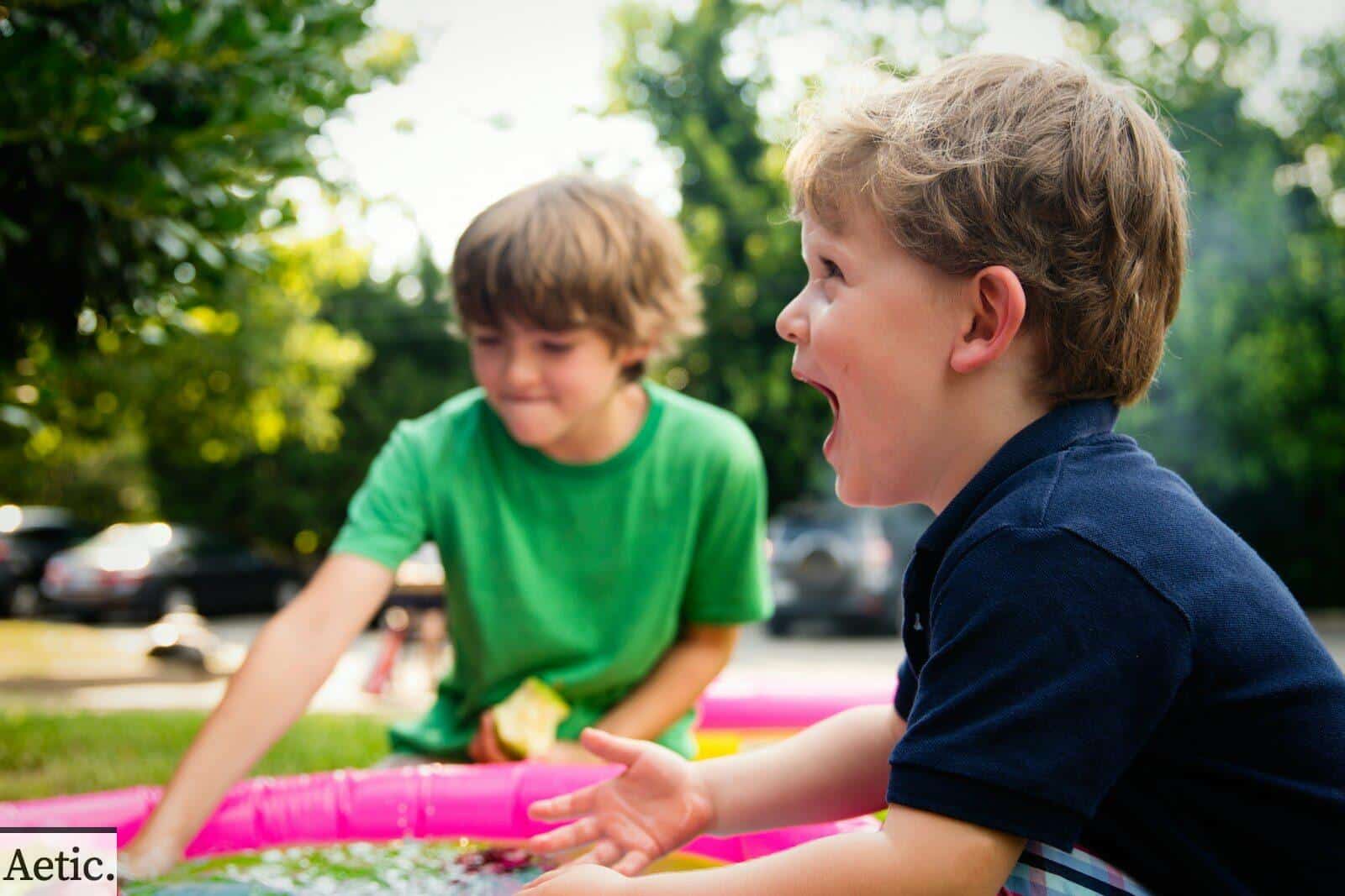 boy in blue shirt screaming near boy in green crew-neck shirt